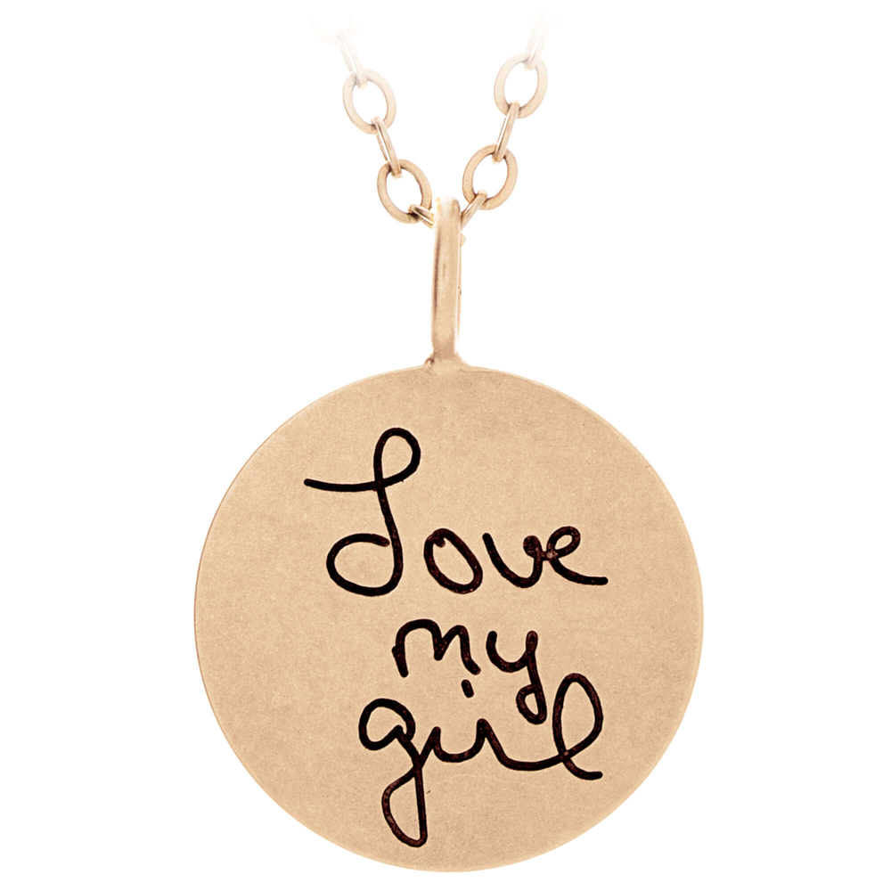 Engraved gold disc with handwriting that reads 'Love my girl'